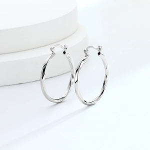 Macro detail of S925 sterling silver hoop earrings with twisted rope texture finish
