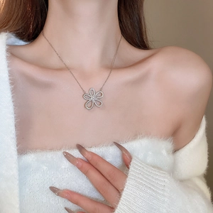 Silver flower pendant necklace with clear crystals worn on a model's collarbone
