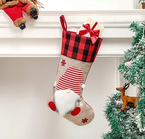 Hanging burlap Christmas stocking with gnome motif and red checkered cuff detail