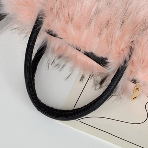 Close-up of pink faux fur texture and black faux leather handle with gold zipper detail