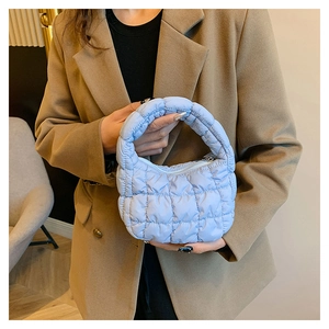 Detail of light blue quilted cloud bag showing soft padded texture and stitching