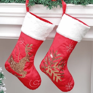Red Christmas stockings with gold sequin reindeer and snowflake on white faux fur