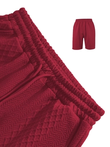 Macro detail of red men's shorts showing textured jacquard fabric and drawstring waist