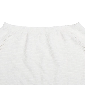 Gros plan sur la texture en tricot blanc et l'encolure ronde minimaliste du haut