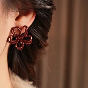 Eleganti orecchini a fiore traforati rosso scuro con design a petali minimalista