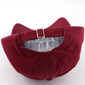 Close-up of wine red washed cotton baseball cap with adjustable metal buckle strap