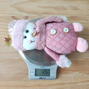 Detail view of a pink plush snowman decor showing its texture and 126g weight on a scale
