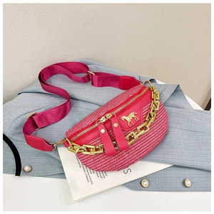 Close-up of pink woven chest bag with chunky gold chain and horse metal logo detail