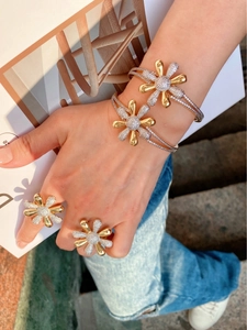 Detail of two-tone daisy flower bracelet and ring set with micro-paved cubic zirconia