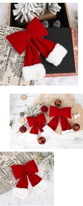 Detail of red velvet Christmas bow with white plush trim and festive holiday ornaments