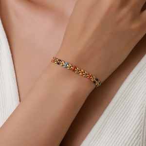 Élégant bracelet feuilles en acier doré avec émail coloré porté par un mannequin