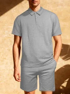 Dettaglio del tessuto a nido d'ape grigio sul set polo e pantaloncini coordinati da uomo