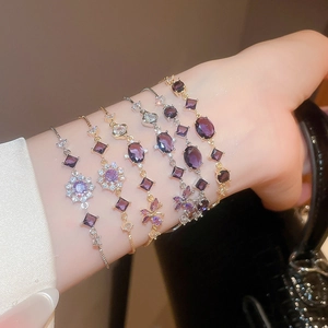 Macro detail of six elegant purple zircon bracelets with adjustable sliding gold chains