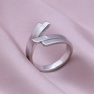 Minimalist silver steel geometric ring displayed on soft purple satin fabric background