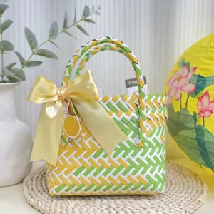 Handwoven basket bag with yellow ribbon and rabbit charm for summer wedding gifts