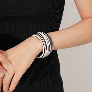Detail of a wide striped acetate cuff bracelet with black and white retro pop pattern