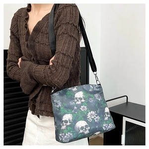 Close-up of a nylon crossbody bag with skull and flower prints on a wide shoulder strap