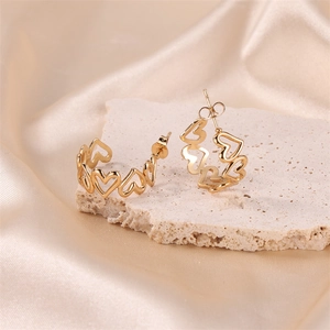Chic hollow heart-shaped gold stud earrings displayed on a luxury textured background