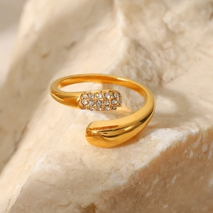 Macro shot of gold snake-style wrap ring with crystals on a textured stone surface