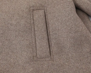 Macro shot of high-density stitching and wool blend fabric on a camel coat pocket