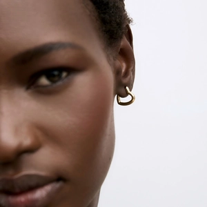 Polished gold heart hoop earrings for women shown on model for a trendy minimalist look