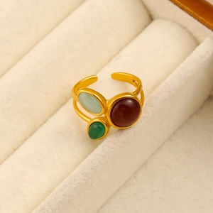 Détail d'une bague plaquée or 18 carats avec trois pierres naturelles sur présentoir velours