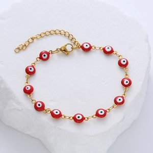 Detail of gold evil eye bracelet with red enamel beads and lobster clasp closure