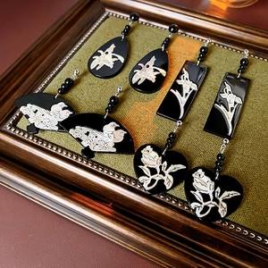 Detail view of four pairs of shell-inlaid earrings in a vintage frame with green fabric