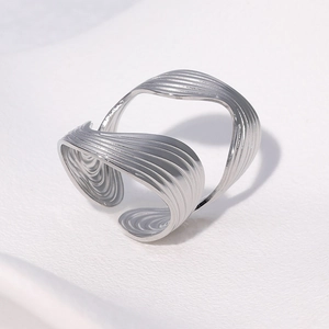 Detailed top view of a silver irregular wavy textured open ring with layered design