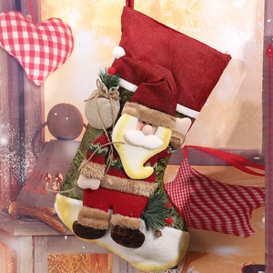 Close-up of 3D Santa Claus character on rustic red and green burlap Christmas stocking