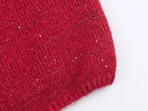 Détail de tricot rouge avec des fils de lurex argentés et de petites paillettes