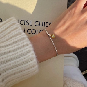 Detail of S925 sterling silver beaded bracelet with gold heart charm on wrist