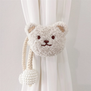 Detailed view of plush bear curtain tieback with woven rope and pearl tassel details