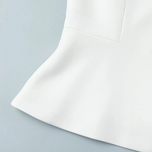 Detailed macro view of white peplum hem with textured fabric on blue background