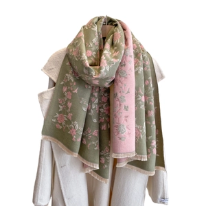 Elegant floral jacquard cashmere scarf with fringes shown on a stylish wool coat