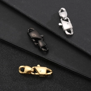 Tre fermagli per catena cubana in argento, oro e nero su superficie in pelle