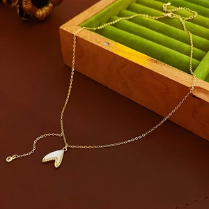 Détail d'un pendentif cœur avec nacre blanche sur un coffret à bijoux en velours vert
