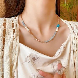 Detail of square aquamarine beads and pearl necklace worn on model for vintage look