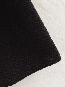 Nahaufnahme der schwarzen Strickstoff-Struktur mit feinem Rippenstrick-Muster