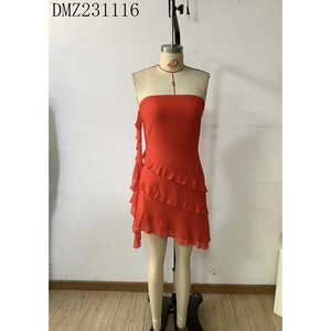 Detail view of red strapless dress featuring multi-layered ruffles and asymmetric hemline