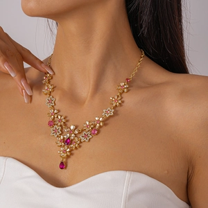 Close-up of a floral necklace with pink and clear crystals on a female model