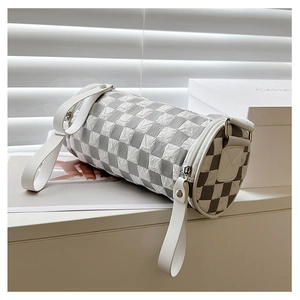 Detailed macro view of the checkered cylindrical crossbody bag with high-quality fabric texture