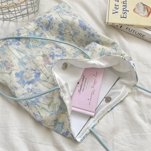 Detail of floral lace embroidery tote bag with silver magnetic closure and satin lining