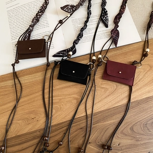 Detailed shot of leather mini pouches with woven cords, wooden beads, and ethnic fabric accents