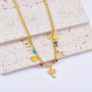 Detail of gold chain necklace with colorful beads and lucky elephant charm charms