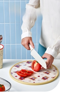 Close-up of double-sided standing cutting board with cartoon bear pattern and a slicer knife