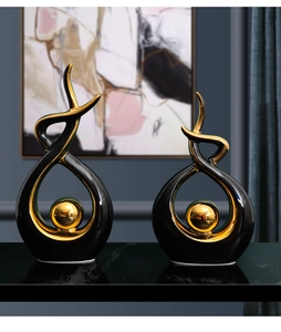 Detail of modern black and gold abstract ceramic sculptures with glossy finish