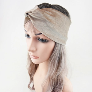 Detailed close-up of champagne velvet twist headband on a model against white background