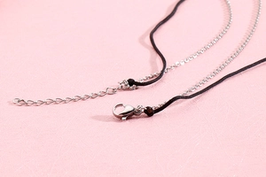 Detail of adjustable lobster clasp and silver extension chain on stainless steel necklace