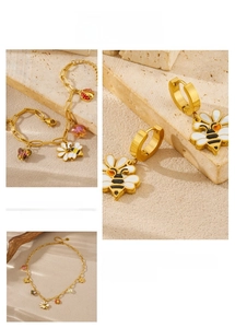 Detail of gold bee and floral enamel jewelry set featuring necklace bracelet and earrings